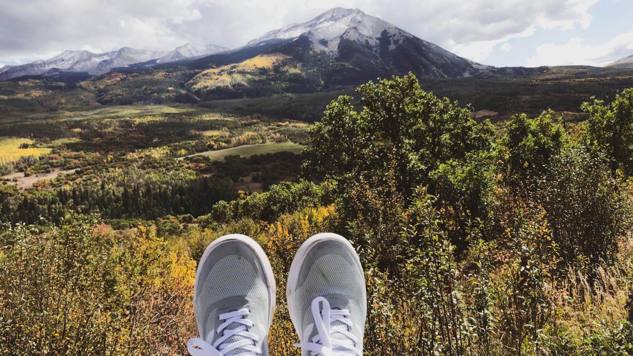 sneakers in front of mountains